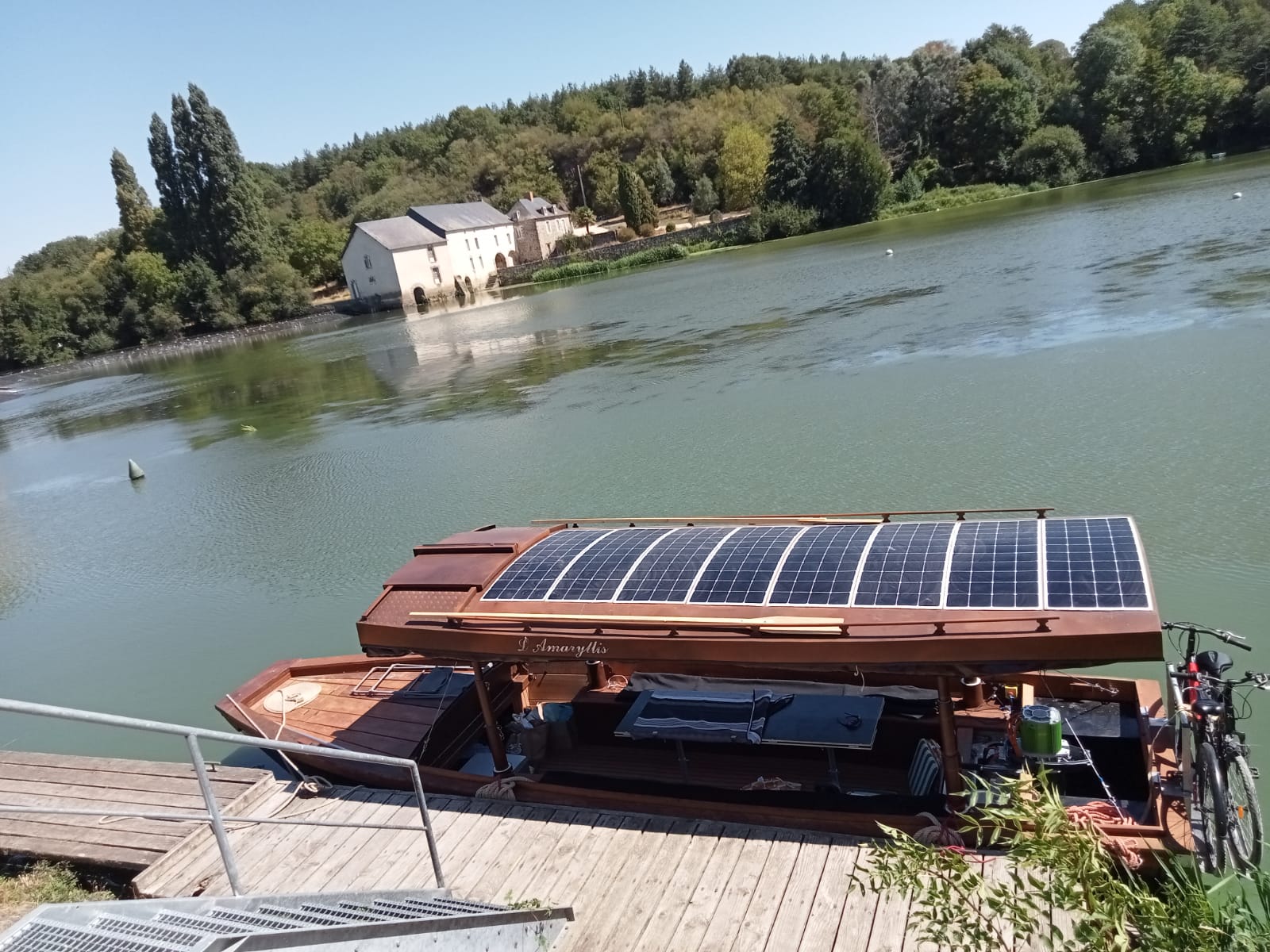Bateau solaire amarré devant maison au bord de la Loire.