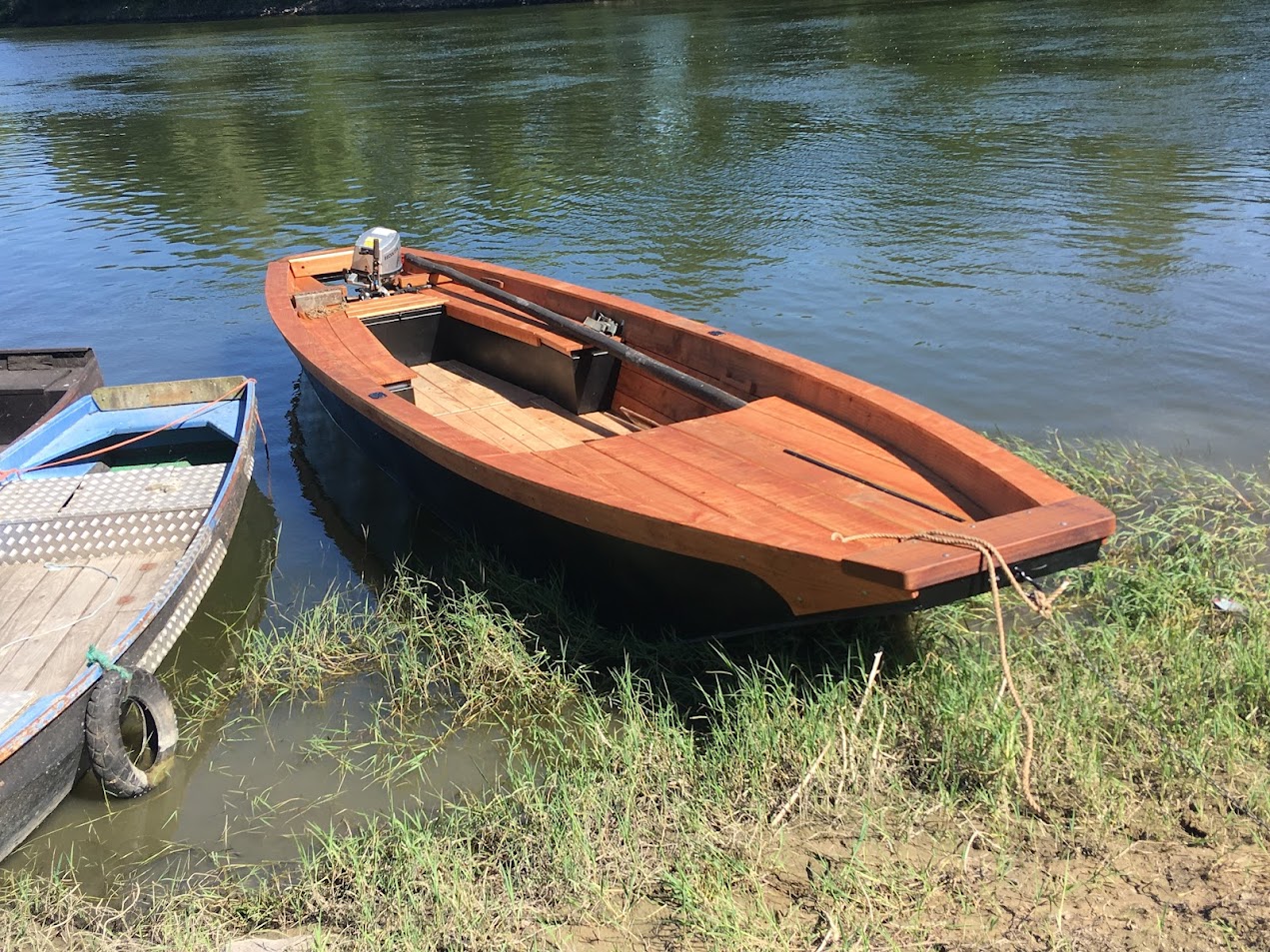 Barque en bois amarrée au bord de l'eau.