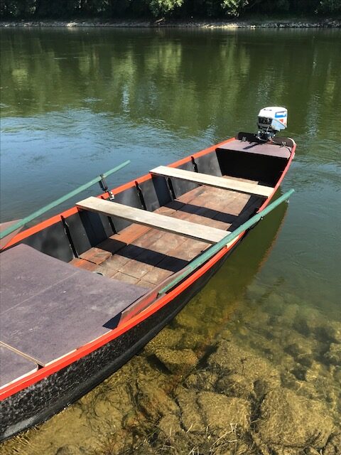 Barque à moteur sur une rivière calme.